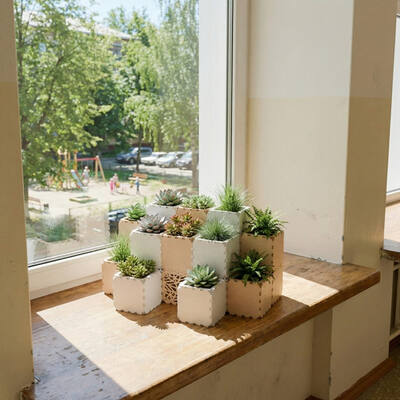White and beige Cubik succulent planters on a wooden windowsill